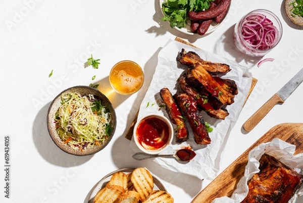 Obraz Grilled pork ribs with a spicy sauce and served with cole slaw, and red onion.