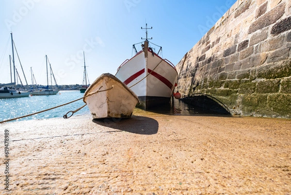 Fototapeta fishing trawler with his tender boat on the hold of the port of Erquy in Brittany