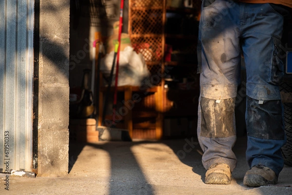 Fototapeta dirty trousers of worker in protective boots for occupational hazards in oil mill are shadows, unrecognisable person