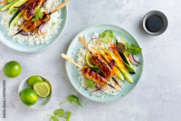 Fototapeta Asian-style kebabs with white rice and a side dish of vegetables