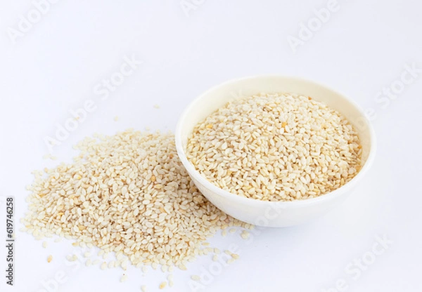 Fototapeta Sesame seeds in a white  bowl isolated on white. High angle.