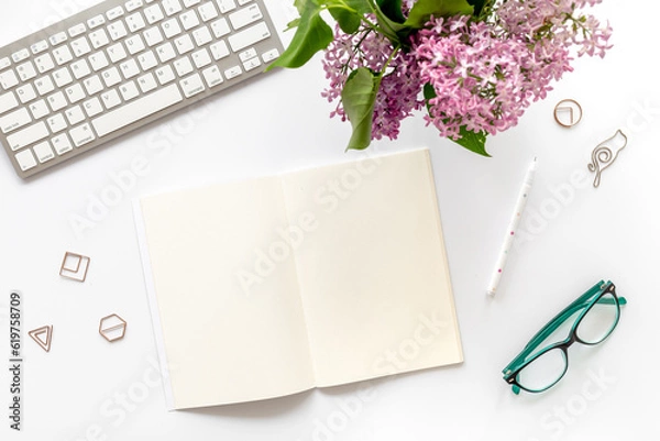 Obraz Bouquet of spring flowers on desktop with computer, top view