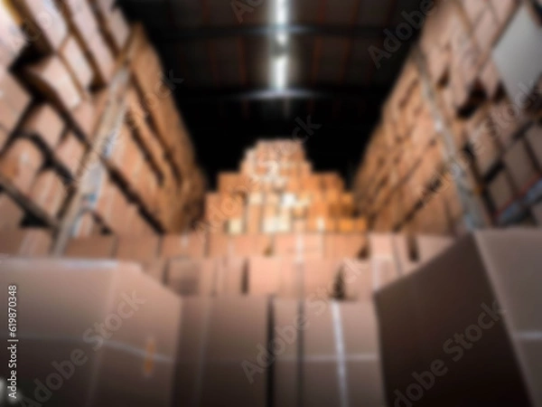 Fototapeta Blurred  A warehouse where the goods are packed in a large number of brown cardboard boxes.