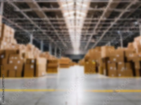 Fototapeta Blurred  A warehouse where the goods are packed in a large number of brown cardboard boxes.