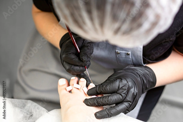 Obraz Application of gel nail polish, aesthetic pedicure procedure,