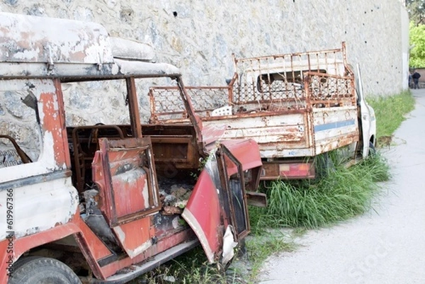 Fototapeta Wreckage Collide: A Tale of Two Dilapidated Vehicles
