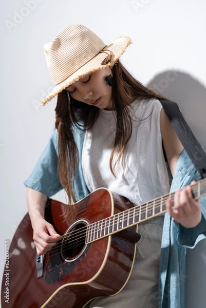 Fototapeta ギターを弾く若い女性