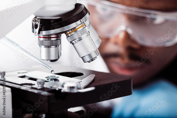 Fototapeta african american scientist in lab working with microscope