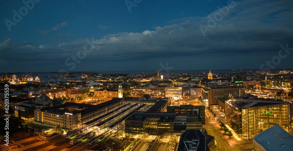 Fototapeta Central train station and city lights glow on summer night in Helsinki