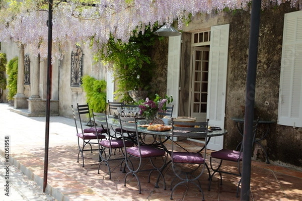 Fototapeta Table on the porch under blooming Wisteria