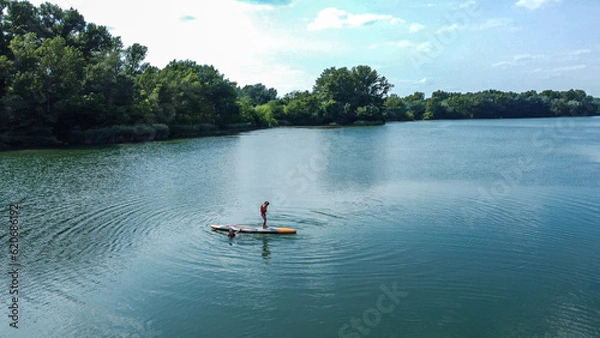 Fototapeta Surfboarding in the Amazon, an extreme sport, a water sport on a board.