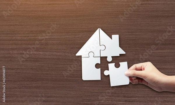 Fototapeta Close up picture of hands holding house jigsaw puzzle. build a house concept.
