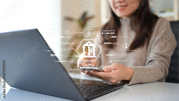 Obraz Woman using computer Laptop conducting online financial transactions through the internet. The concept of Mobile Banking or Virtual Banking technology that is convenient, emphasizing safety.