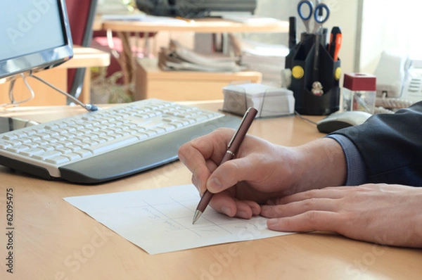 Obraz Man writes something on a white paper. Office work