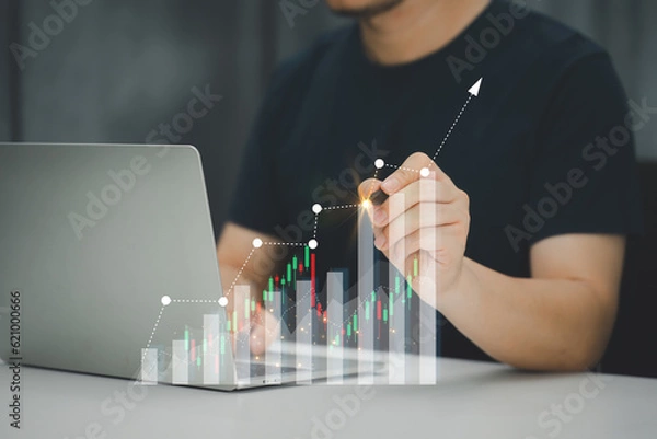 Fototapeta A businessman or accountant using laptop to analyze financial investments and business and marketing growth on a data graph. The concepts of accounting, economics, and commercial analysis.