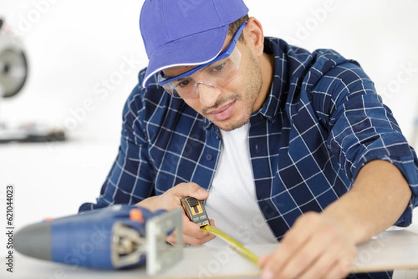 Fototapeta the builder worker measures something