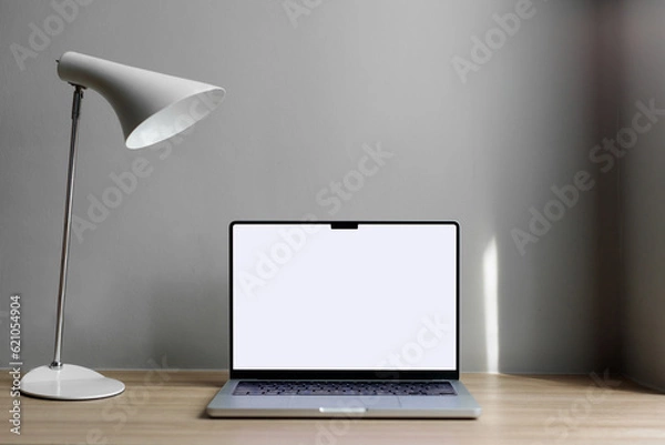 Fototapeta laptop on the table with space for a signature. Macbook 14 pro 2021. gray wall, hotel workplace.copy space