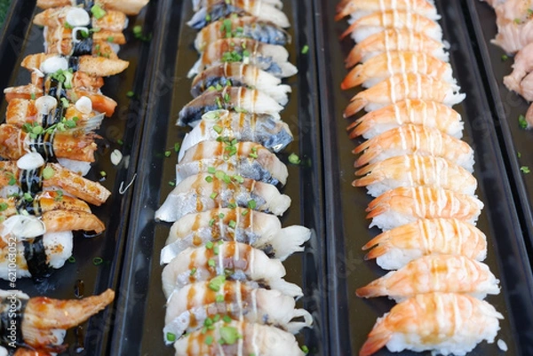 Fototapeta Salmon and shrimp sushi arranged in a row.