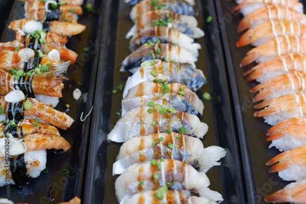 Fototapeta Salmon and shrimp sushi arranged in a row.