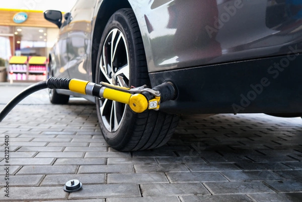 Fototapeta Refueling a car with lpg. Gas Station Filling Up the Gas Tank. Refueling with Liquefied Petroleum Gas.
