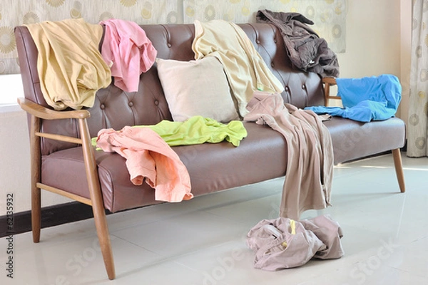 Obraz Messy clothes scattered on a sofa in living room