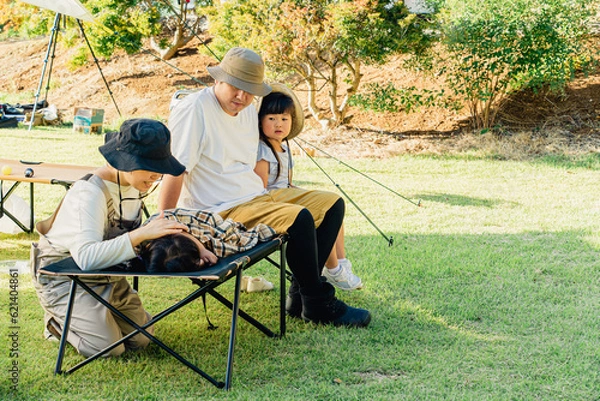 Fototapeta キャンプ場に来て遊び疲れてコットに眠る子供（体調不良・発熱）

