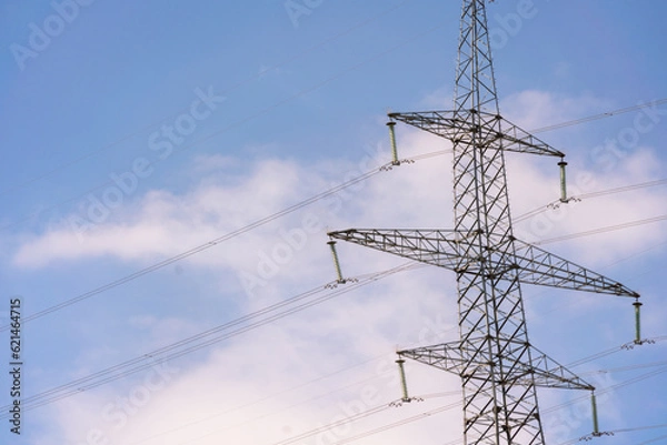 Fototapeta High voltage towers with sky background. Power line support with wires for electricity transmission. High voltage grid tower with wire cable at distribution station. Energy industry, energy saving
