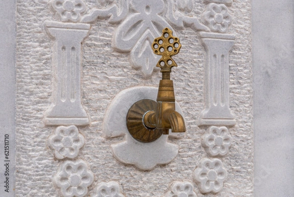 Fototapeta patterned marble floor in the background of the old bronze faucet