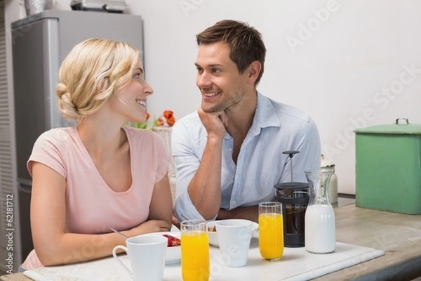 Fototapeta Couple looking at each other at breakfast table