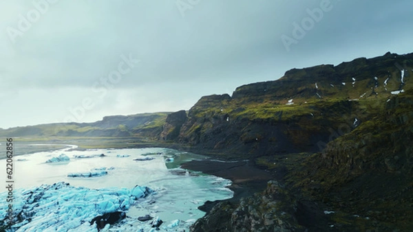 Obraz Drone shot of majestic icebergs in iceland floating on frozen lake, vatnajokull glacier cap. Beautiful scandinavian icy frosty blocks forming icelandic landscapes, polar scenery. Slow motion.