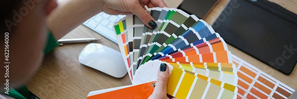 Fototapeta Female designer holding color samples and choosing color samples for projects.