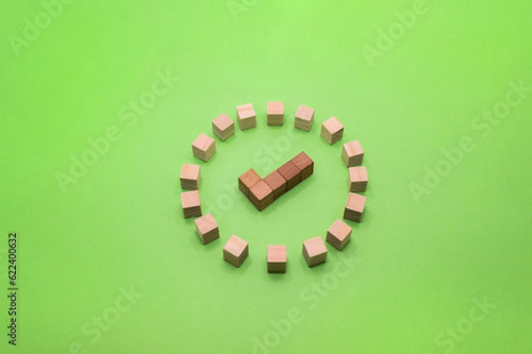 Fototapeta 緑の背景の中央にチェックマークの形をした木製の茶色い丸いアイコン