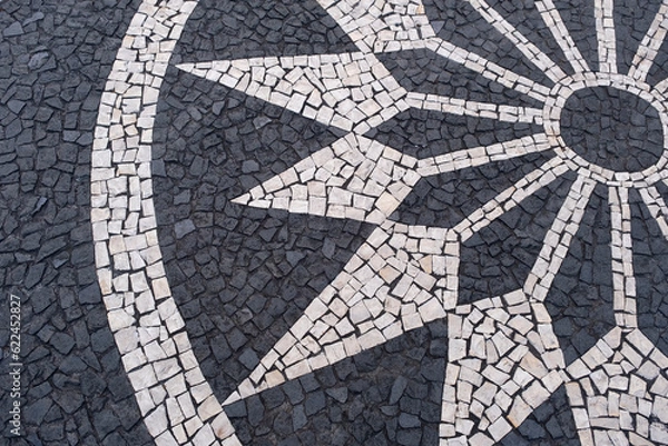 Fototapeta Portuguese traditional black and white pavement made from calcada tiling. Fragment of sidewalk paving in Funchal, Madeira island