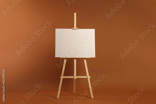 Fototapeta Wooden easel with blank canvas on brown background