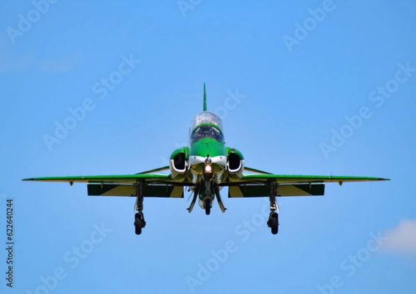 Fototapeta single green saudi Hawks falcons aerobatic team fighter jet face on coming in to land with blue skies air show display teams
