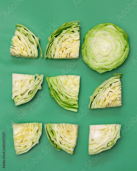 Obraz Cabbage cut into pieces top view on a green background