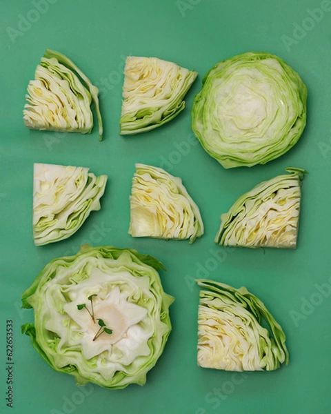 Obraz Cabbage cut into pieces with microgreens top view on a green background