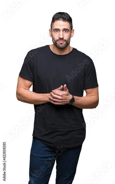 Fototapeta Young handsome man over isolated background Hands together and fingers crossed smiling relaxed and cheerful. Success and optimistic