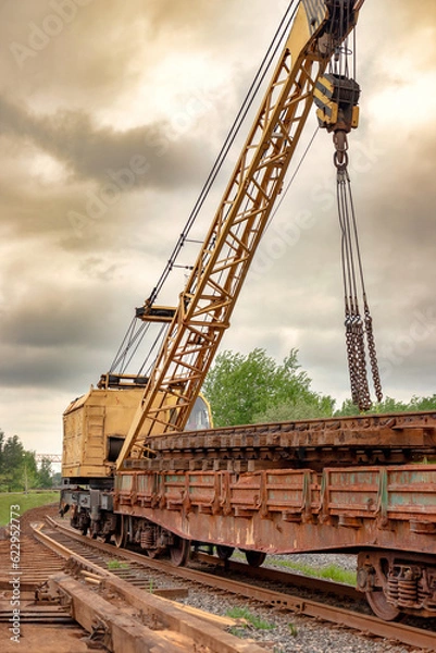 Fototapeta Mobile railway crane on a platform. Replacement and repair of railroad sleepers and other elements. Repair and reconstruction of the railway.