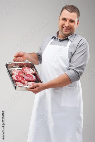 Obraz professional butcher holding red meat.