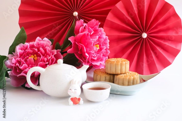 Obraz Chinese Mid-Autumn Festival concept made from mooncakes, tea decorated with plum blossom, red paper fans and rabbits isolated on white background.