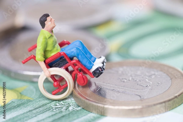 Obraz Rollstuhlfahrer auf einem Geldstapel