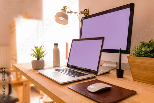 Fototapeta Laptop and TV on the desk, in light colors.