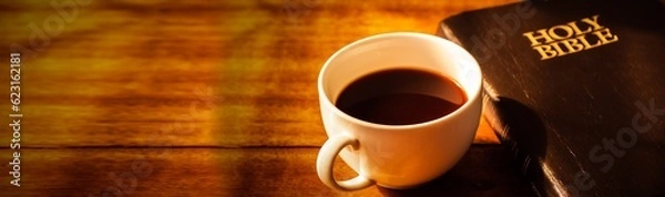 Fototapeta Close up of a cup of coffee and holy bible  on wooden table, Bokeh light effected for web page cover