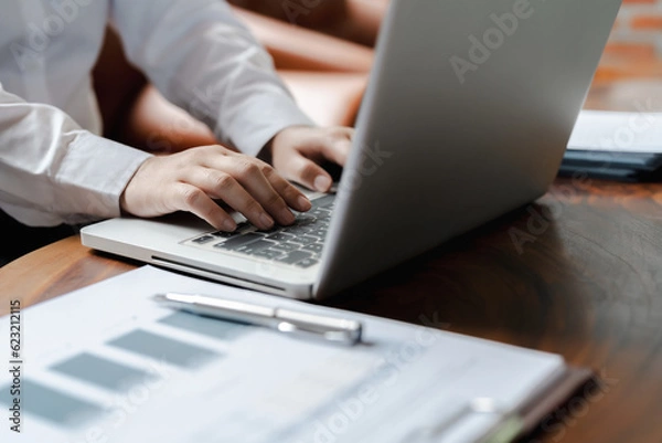 Fototapeta Business person typing on laptop keyboard working with digital data..