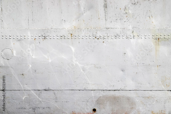 Fototapeta Riveted with button-head rivets metal plate - side of a sea vessel - painted in white as a background