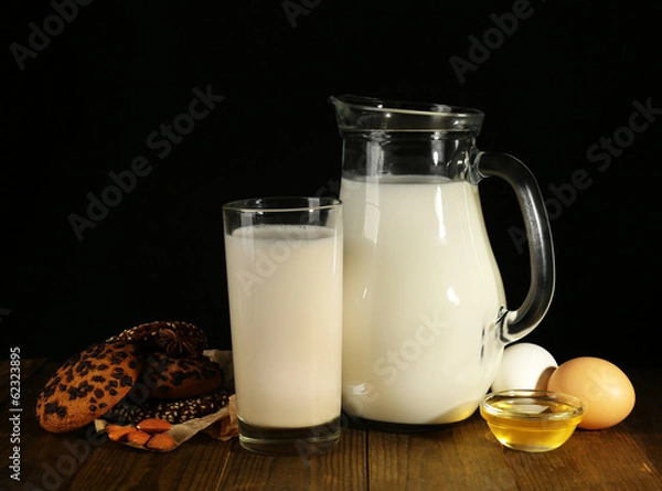 Fototapeta Eggnog with milk and eggs on table and black background