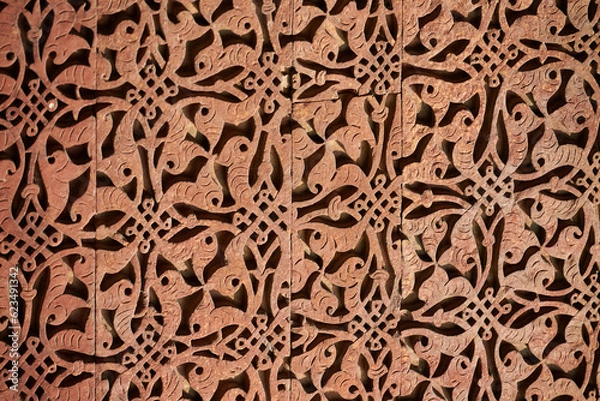 Fototapeta Wall decorative patterns of Qutb complex in South Delhi, India, close up ancient bas relief wall decorations of mosque ruins landmark, popular touristic spot in New Delhi, ancient indian architecture