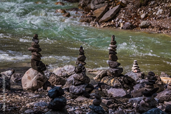Obraz Stoamandl vor einem Bayerischer Wildbach in den Alpen. Oft sieht man in den Bergen diese Steinmännchen, die früher als Wegweiser dienten, heute eher aus Spass aufgestellt werden.