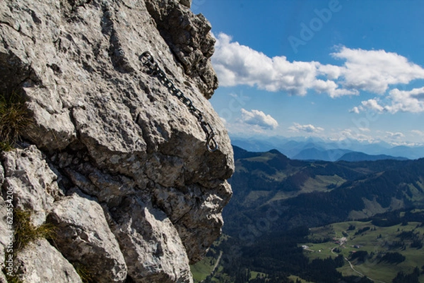 Obraz Sicherungskette mit Edelstahl-Umlenker in einer Kletterroute der Käsererwand in den Bayerischen Alpen. Die Kalksteinfelsen der Kaesererwand bieten den Kletteren viele gut abgesicherte Klettertouren